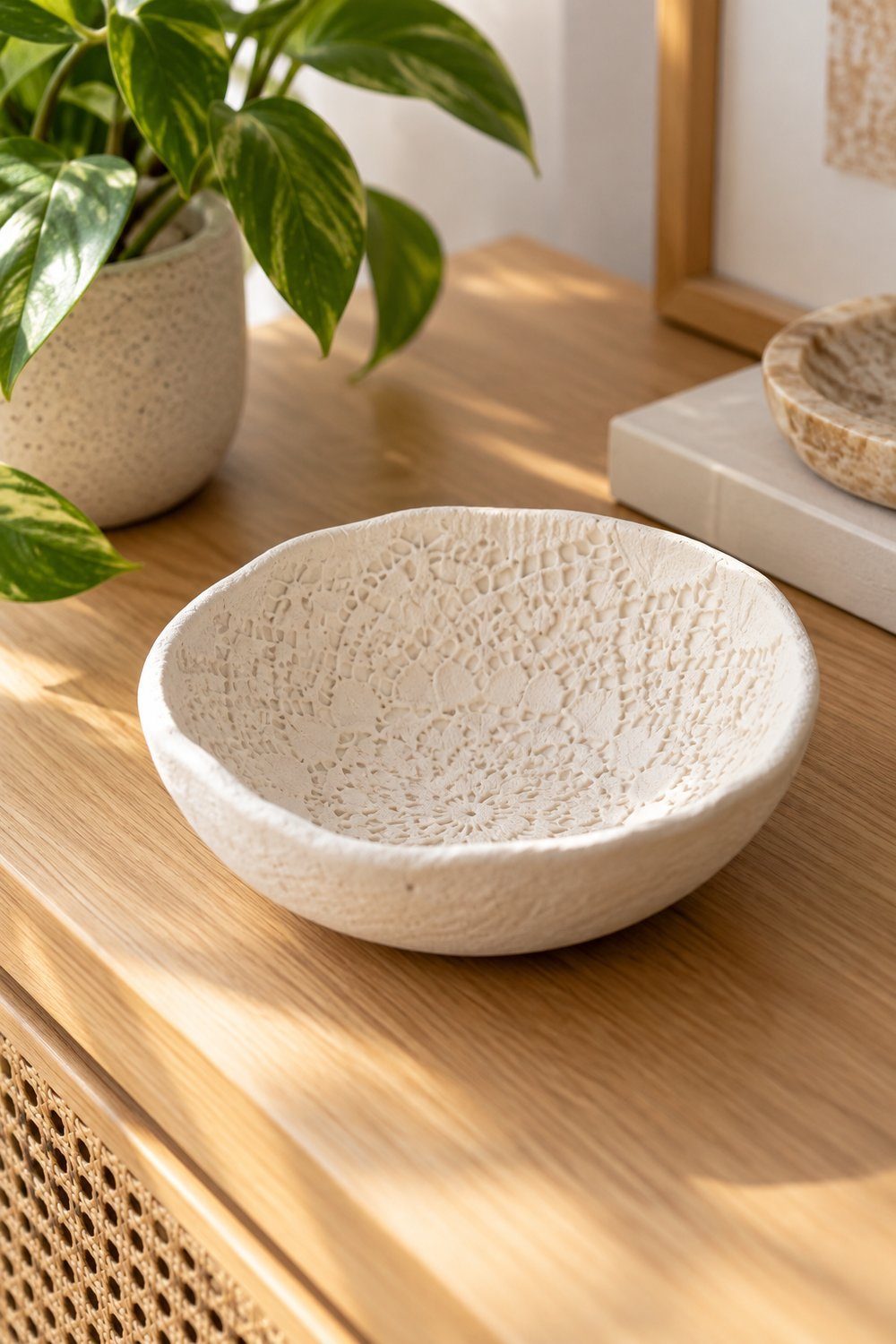 Tigela branca de argila com textura delicada de renda no interior